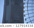 Tall building and Ferris wheel 127914338