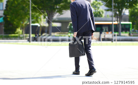 A young businessman walking with his shoulders slumped A young businessman walking with his shoulders slumped 127914595