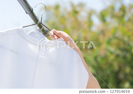 Woman's hands drying laundry 127914659
