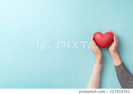 Hands Holding a Red Heart Against a Light Blue Background for Love and Affection Concepts Hands Holding a Red Heart Against a Light Blue Background for Love and Affection Concepts 127914701