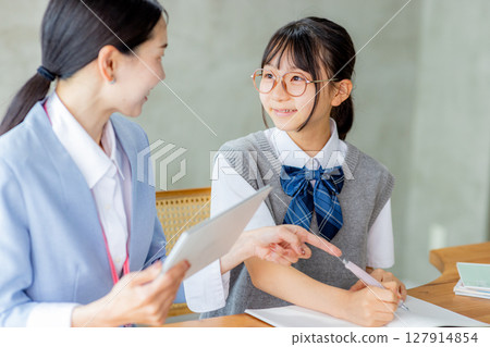 Junior high school students studying and their teacher 127914854