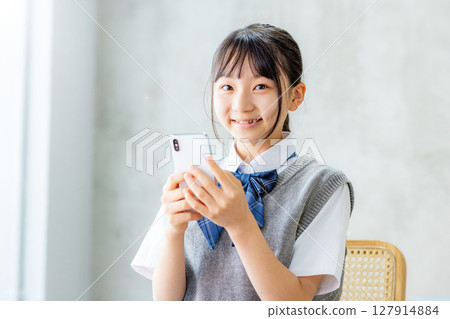 看著智能手機的女初中學生 127914884