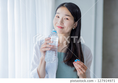 Young woman drinking water Young woman drinking water 127914971