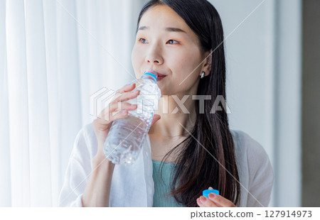 Young woman drinking water Young woman drinking water 127914973