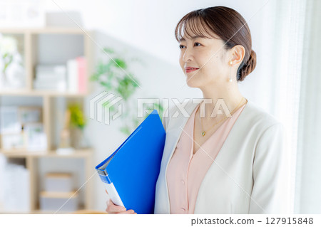 Business woman smiling and holding files Business woman smiling and holding files 127915848