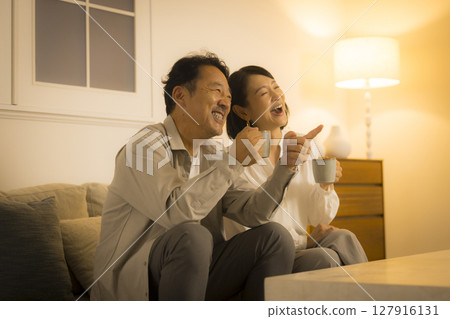 Middle-aged couple in the living room at night 127916131