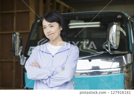 Middle-aged woman standing in front of a truck 127916181