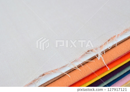 stack of colourful cotton clothes, close up pile of clothing 127917121