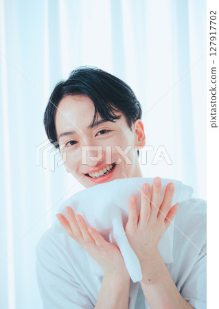 A clean-cut man in his 20s washing his face and taking care of his skin 127917702