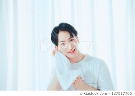 A clean-cut man in his 20s washing his face and taking care of his skin 127917706
