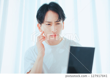 清爽的男士在鏡子前檢查自己的肌膚-男士護膚習慣 清爽的男士在鏡子前檢查自己的肌膚-男士護膚習慣 127917841