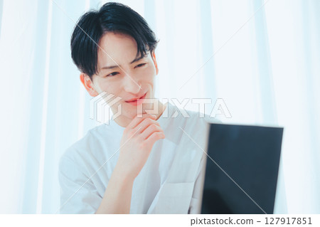 A refreshing guy checking his skin in the mirror — Men's skin care habits A refreshing guy checking his skin in the mirror — Men's skin care habits 127917851