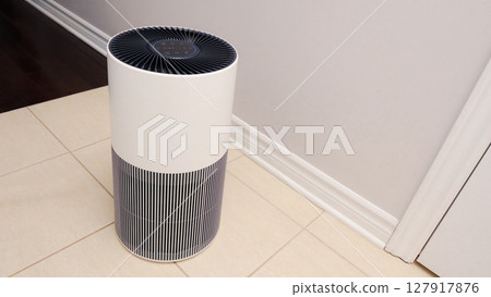 Sleek Modern Tall Air Purifier with Black Fan on Beige Tile Floor in Stylish Room 127917876