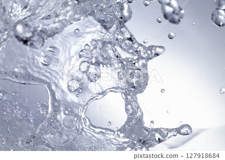 水濺在藍色背景上。 127918684