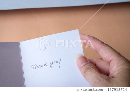 Holding a thank you card up close. 127918724