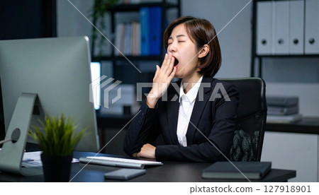 A tired looking businesswoman at work 127918901