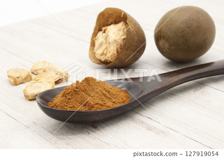 Dried Monk fruit on a white board and Monk fruit extract powder in a spoon Dried Monk fruit on a white board and Monk fruit extract powder in a spoon 127919054
