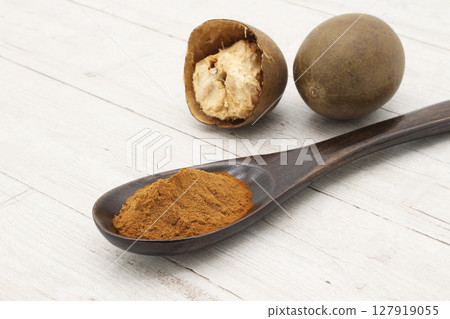 Monk fruit on a white board and monk fruit powder in a spoon 127919055