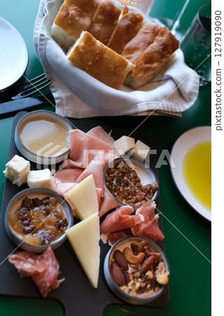 Mediterranean charcuterie board with various kinds of snacks for sharing on concrete background, top view Mediterranean charcuterie board with various kinds of snacks for sharing on concrete background, top view 127919090