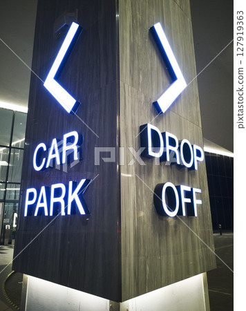Close-up illuminated signs of car parking and drop-off point on the building Close-up illuminated signs of car parking and drop-off point on the building 127919363