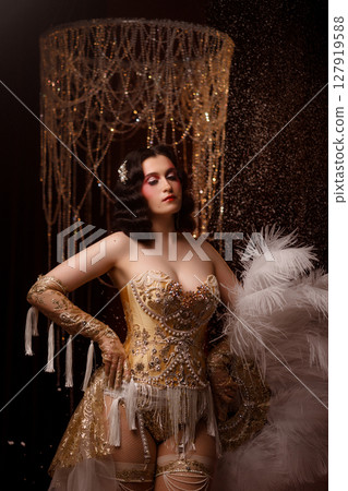 Young woman in vintage corset costume posing under chandelier on dark background Young woman in vintage corset costume posing under chandelier on dark background 127919588