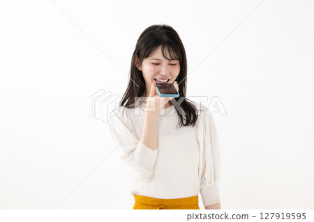 Woman talking to smartphone, voice control 127919595