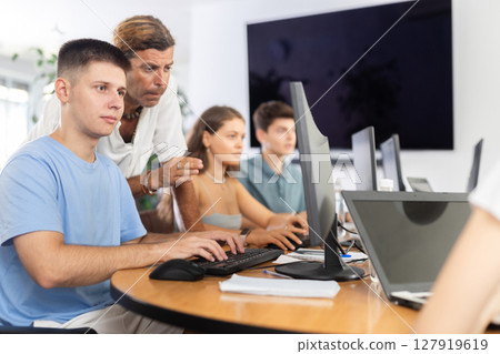 Motivated young trainee developer working at IT startup with mentor 127919619