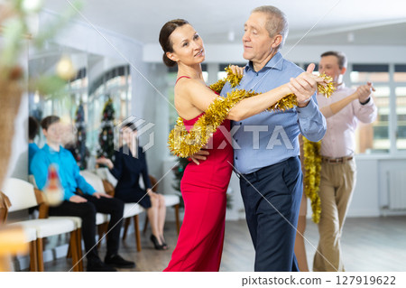 Elderly man dancing slow dance with woman during New Year corporate party 127919622