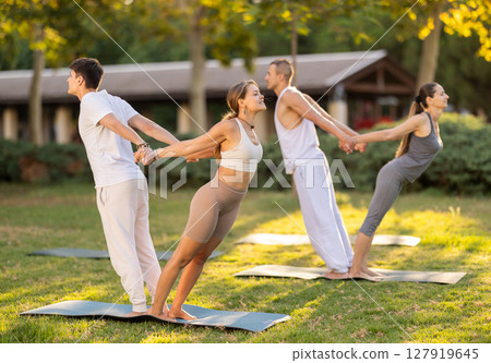 Guy and girl practice pair yoga doing Backbend Balance pose asana Guy and girl practice pair yoga doing Backbend Balance pose asana 127919645