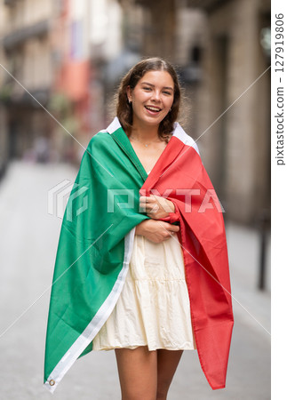 Young woman wrapped in Italian flag on city street Young woman wrapped in Italian flag on city street 127919806