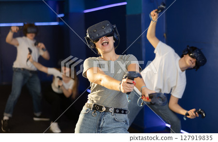 girl in virtual reality helmet crouches down and dodges flying asteroids during space adventure game 127919835