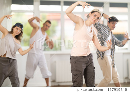 Young girl practicing basic hip hop moves in training hall 127919846