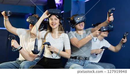 Modern people wearing virtual reality headset playing video games together 127919948
