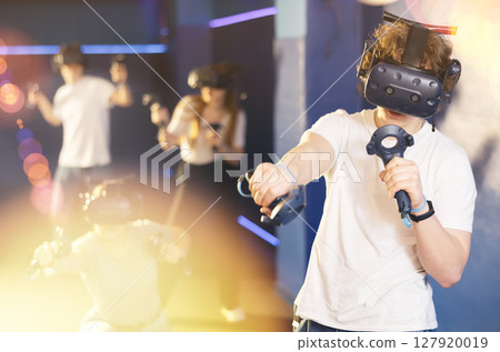 Excited guy having fun with friends in virtual reality room 127920019