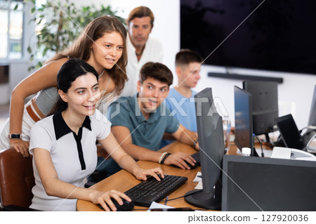 Excited young students engaging in group study session in computer lab Excited young students engaging in group study session in computer lab 127920036