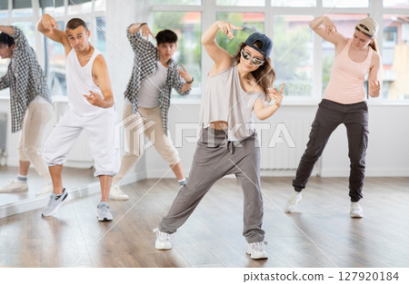 Group of young people perform choreographic exercises and teaches energetic mobile social dance waacking together 127920184