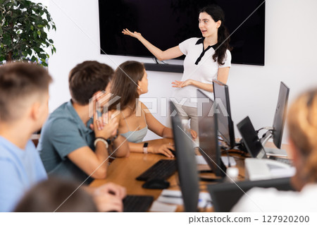 Young girl speaker stands in front of students and talks about use of artificial intelligence 127920200