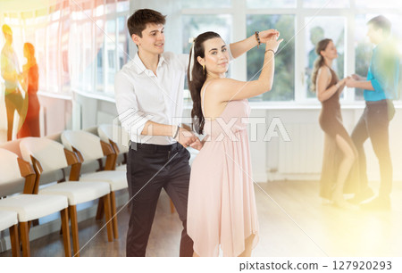 Young couples learning to dance latin american dances in dance studio Young couples learning to dance latin american dances in dance studio 127920293