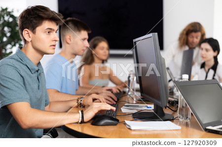 Concentrated junior software developer working in IT startup 127920309