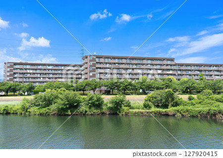 河邊的一棟棕色低層公寓大樓 127920415