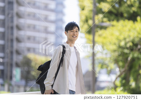 一位 40 多歲的男子微笑著走在街上 127920751