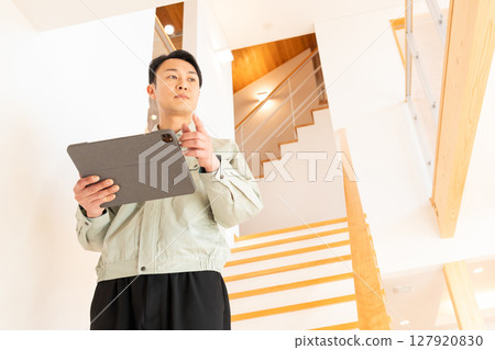 Construction worker inspecting the interior of a house Construction worker inspecting the interior of a house 127920830