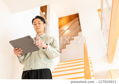 Construction worker inspecting the interior of a house Construction worker inspecting the interior of a house 127920831