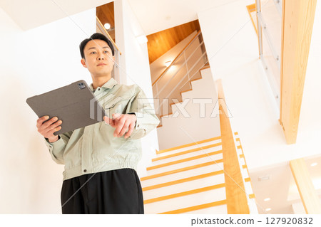 Construction worker inspecting the interior of a house 127920832