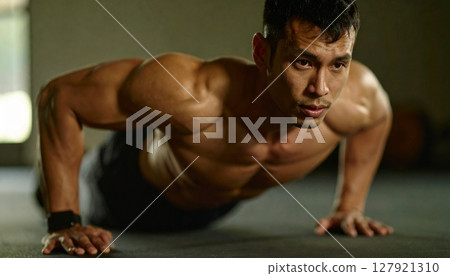 A man doing push-ups at a gym 127921310