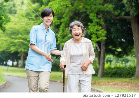 Senior woman and caregiver taking a walk 127921517