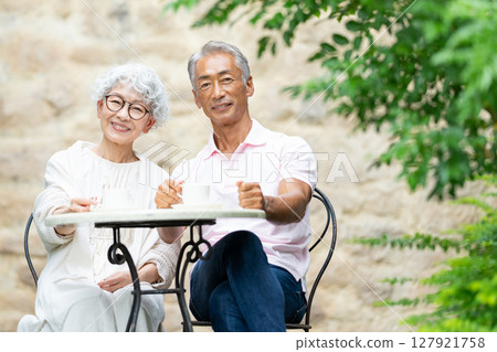 一對老夫婦坐在長椅上喝茶 127921758