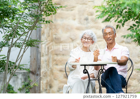 一對老夫婦坐在長椅上喝茶 127921759