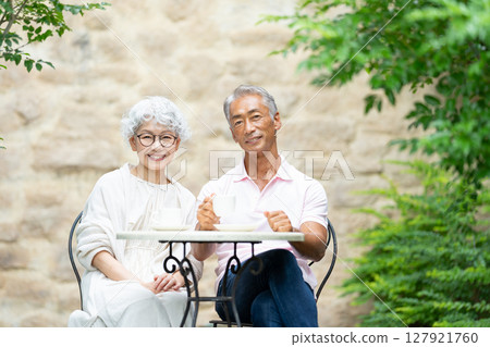 一對老夫婦坐在長椅上喝茶 127921760