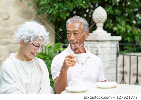 Senior couple drinking coffee in the garden 127921772